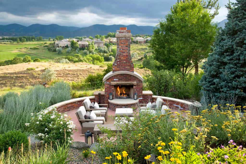 circular outdoor patio area with a red brick fireplace and seating,