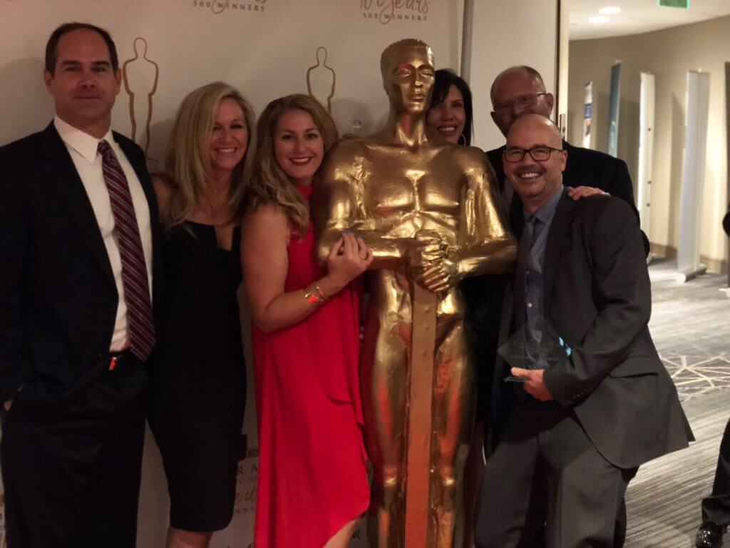 group posing with gold statue