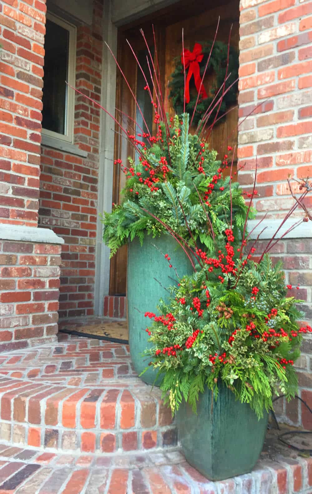 pair of green ceramic pots with red berry winter planters