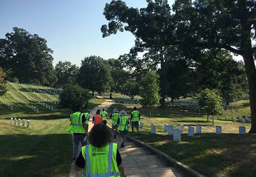 group of people wearing neon vests walking in cemetery