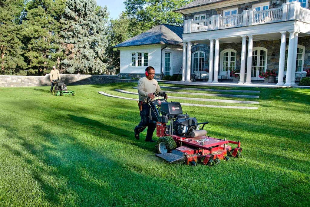 men mowing lawn at large estate