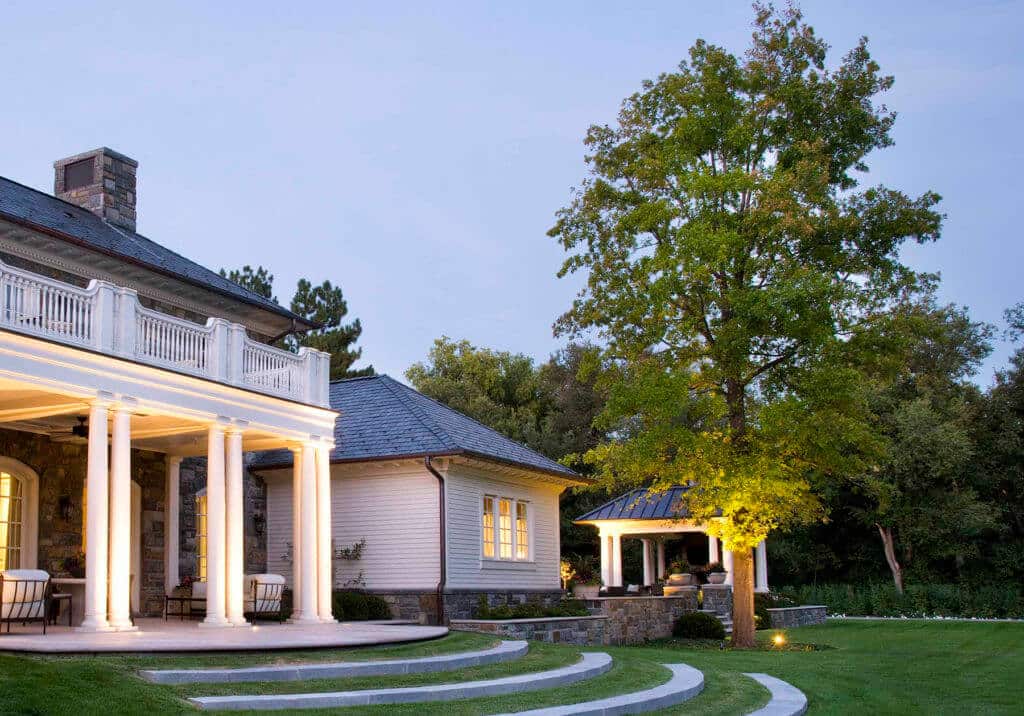 large estate home exterior with landscape lighting at twilight