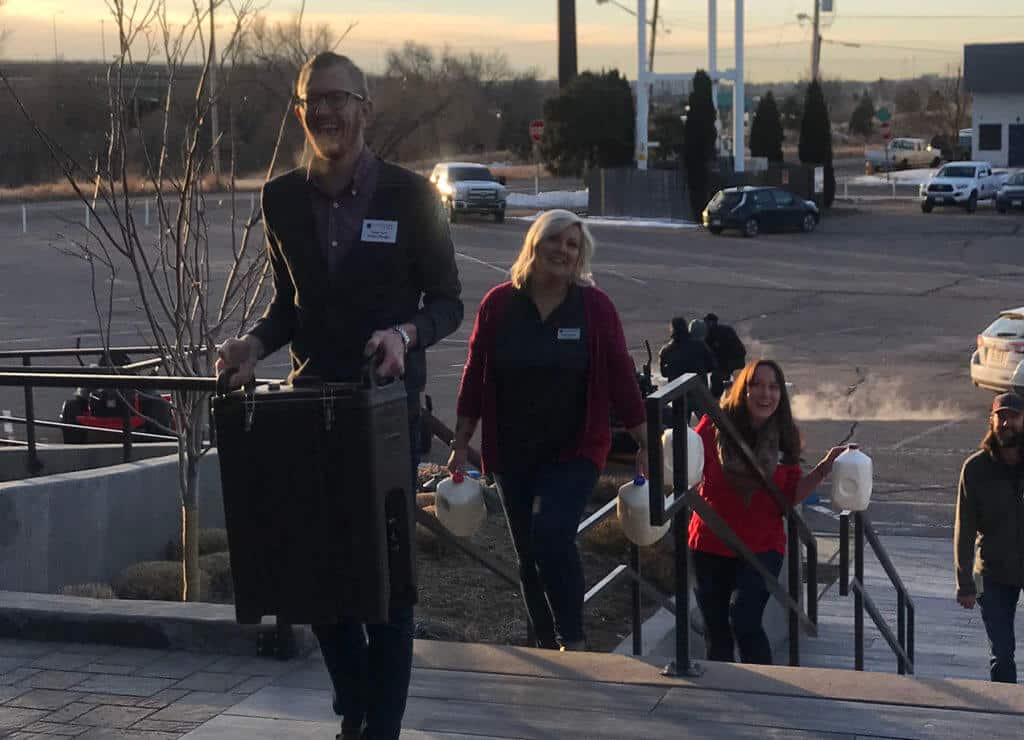 group of people carrying supplies up outdoor stairs