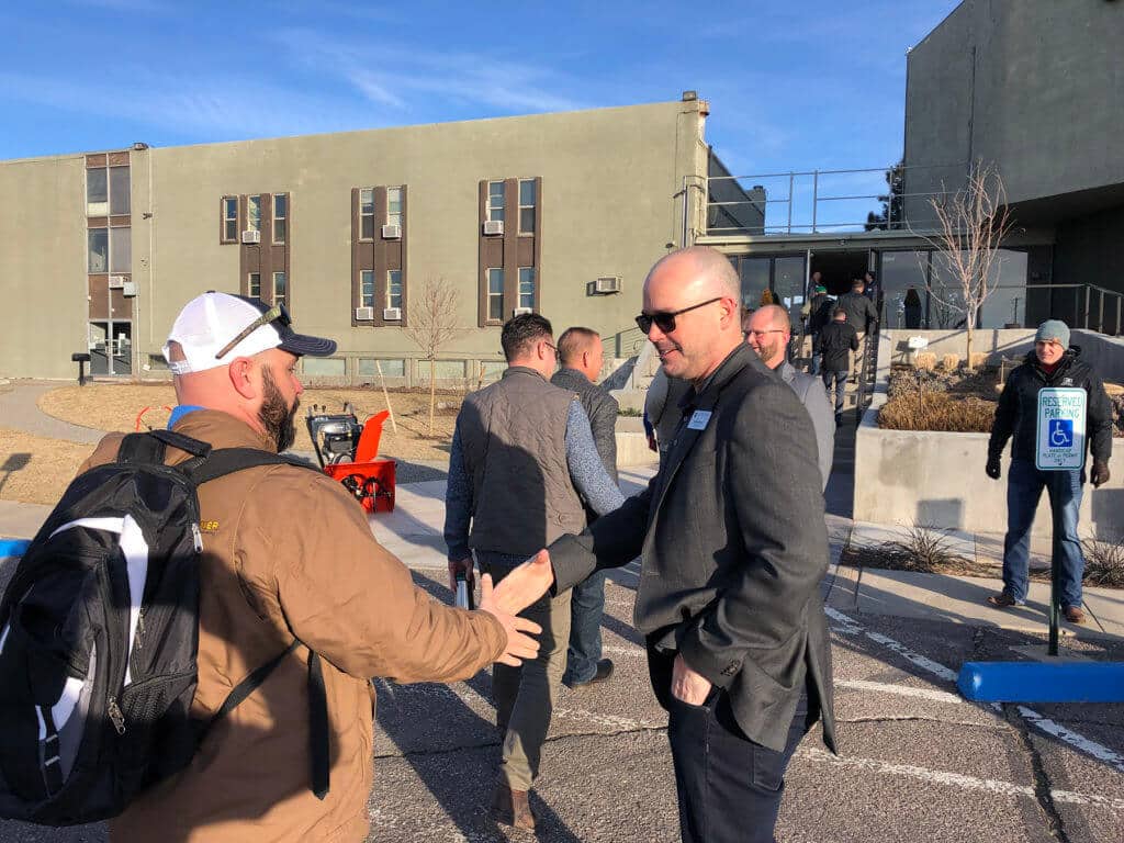 two men shaking hands outdoors