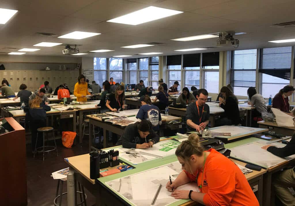large group of students working at drafting tables in a classroom