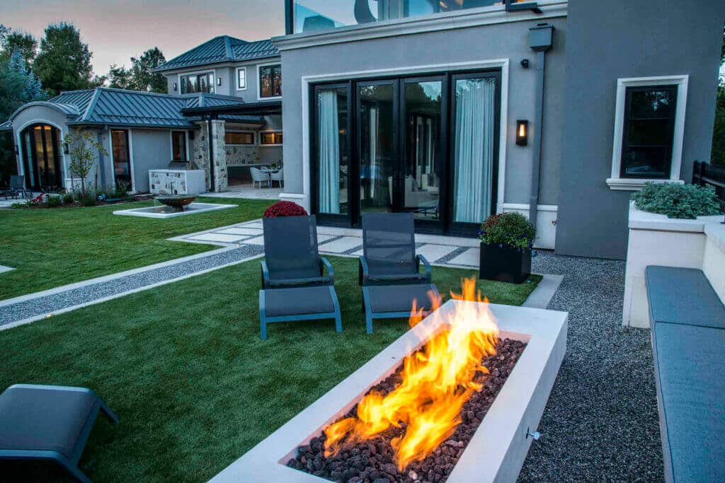 contemporary backyard landscape featuring a rectangular linear gas fire pit