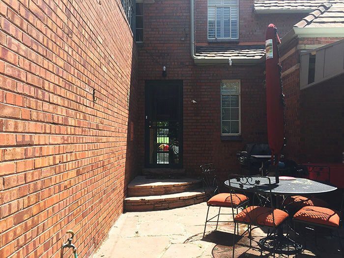 narrow outdoor patio area between two brick buildings