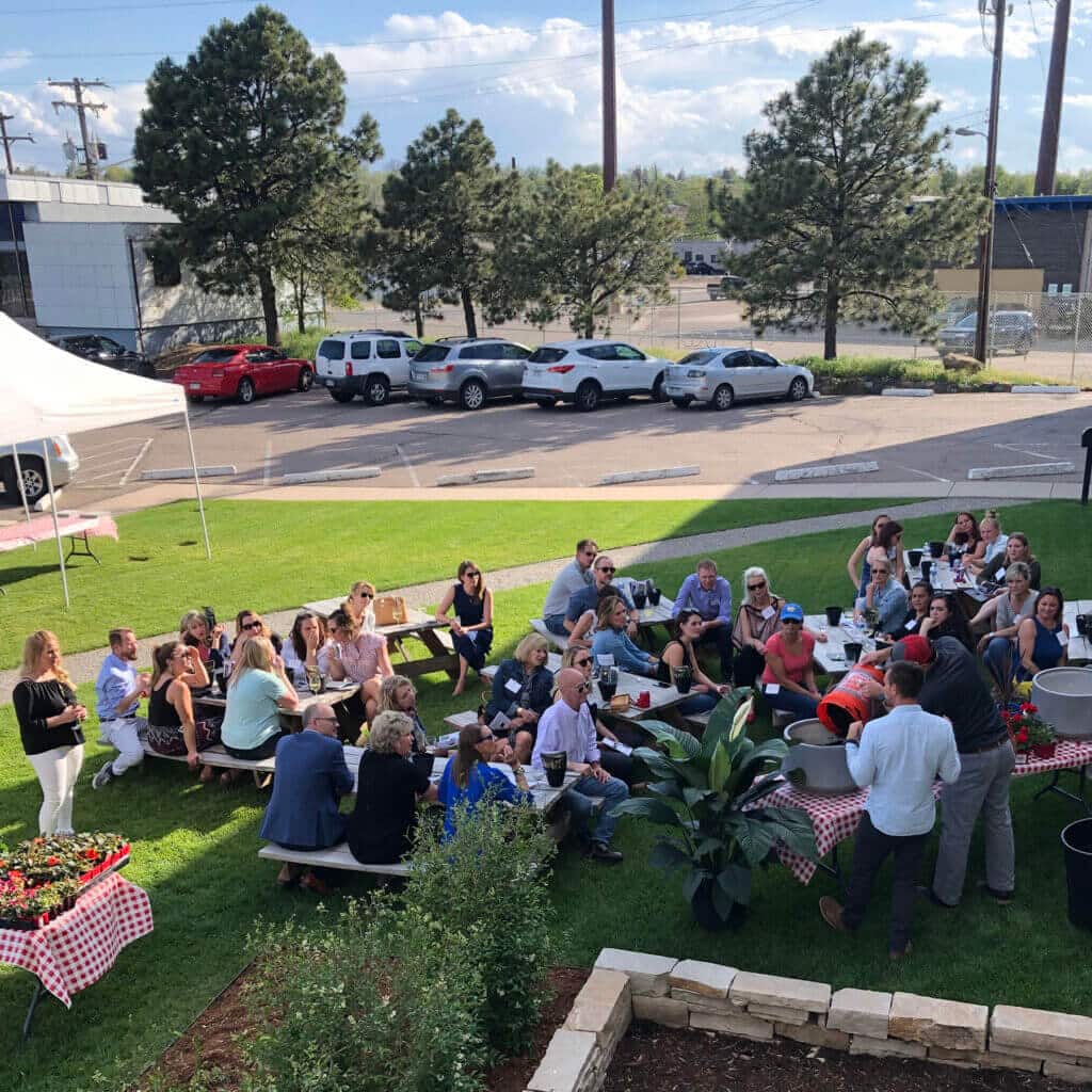 large group of adults attending an outdoor event in a grassy area