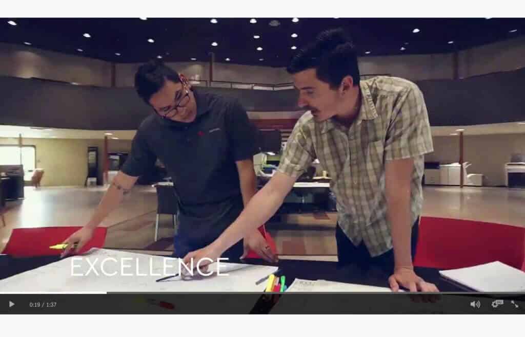video still showing two young men in an office or presentation space