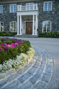 cobblestone drive curves toward manor