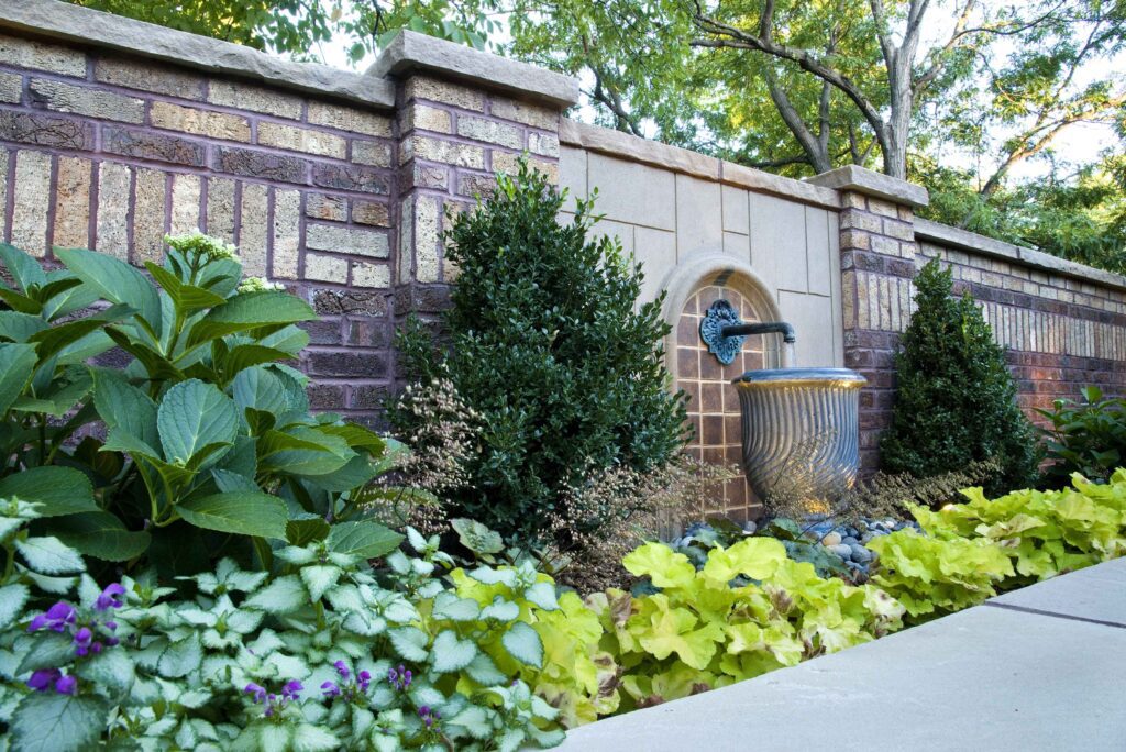 wall fountain flows into garden urn