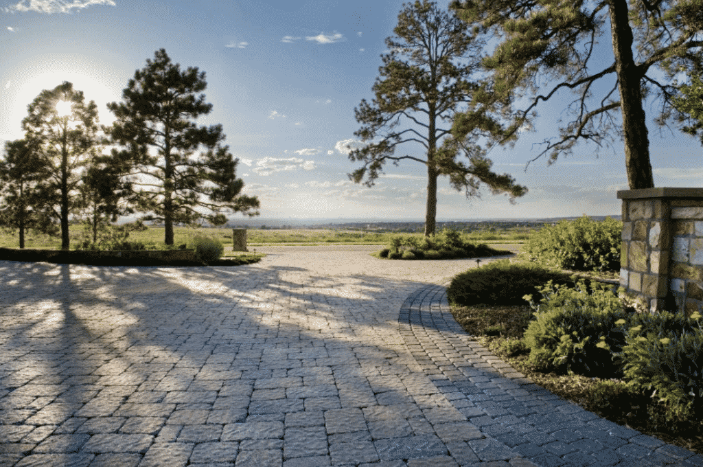 sunlight highlights textured stone driveway.