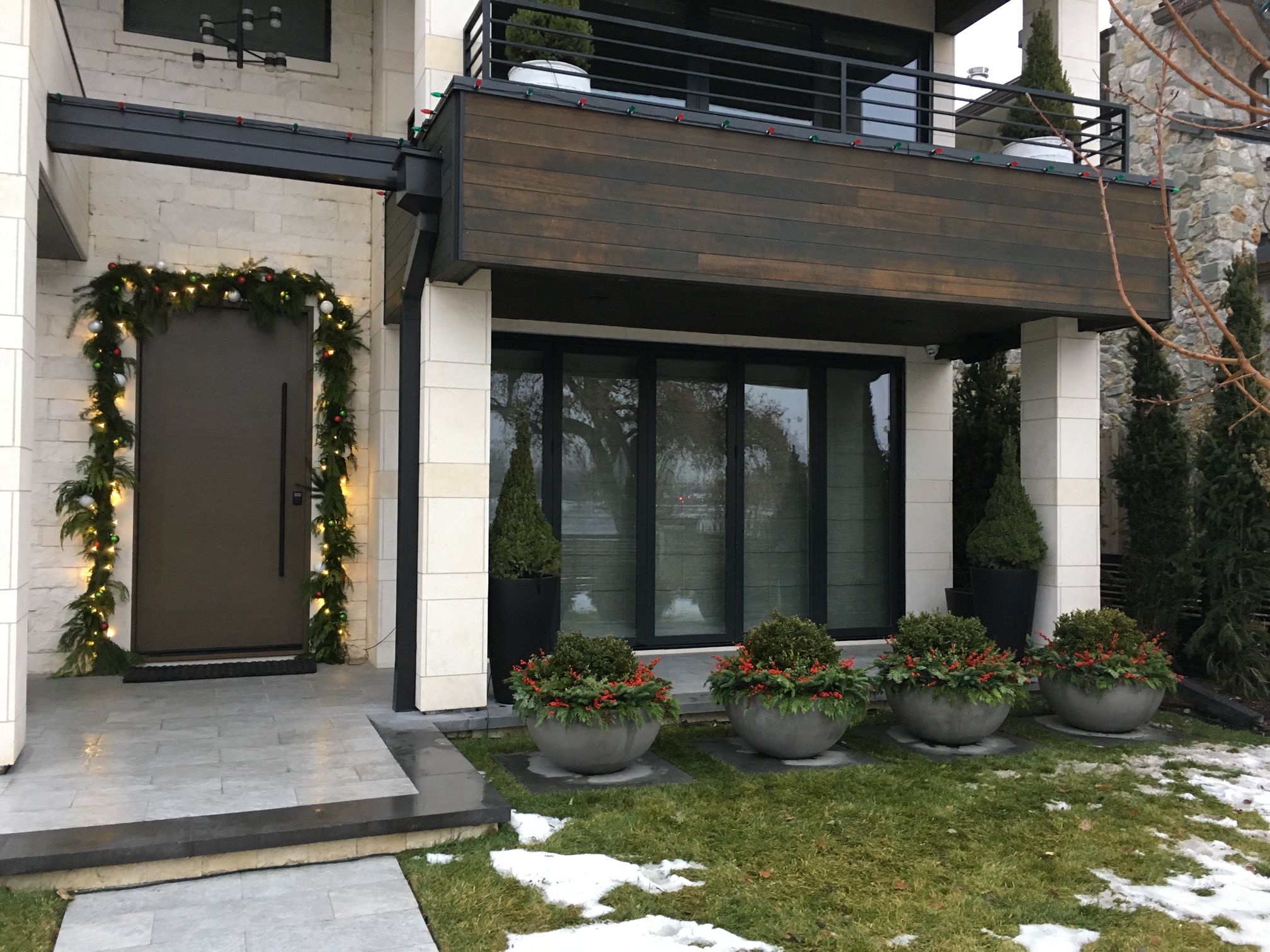 Festive garland frames modern front door.