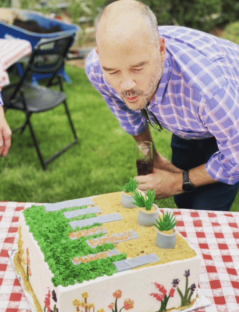 man blows out birthday candles