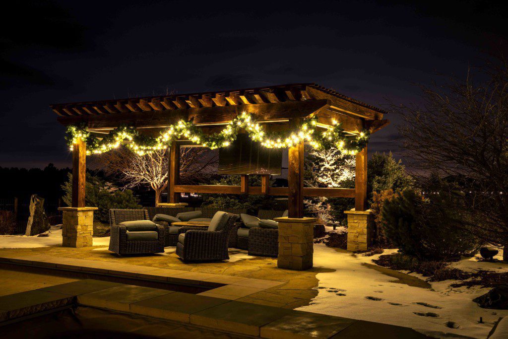 lighted garland decorates dark pergola